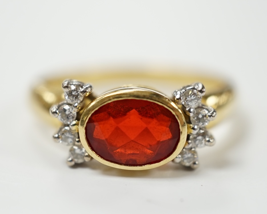 A modern 18ct gold, single stone fire opal? and eight stone diamond chip set dress ring, size L/M, gross weight 5.3 grams. Condition - fair to good